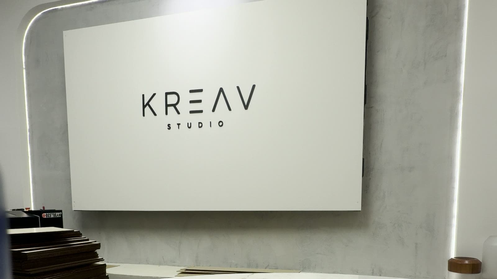 Placa da Kreav com moldura de LED sobre a mesa de mármore do estúdio