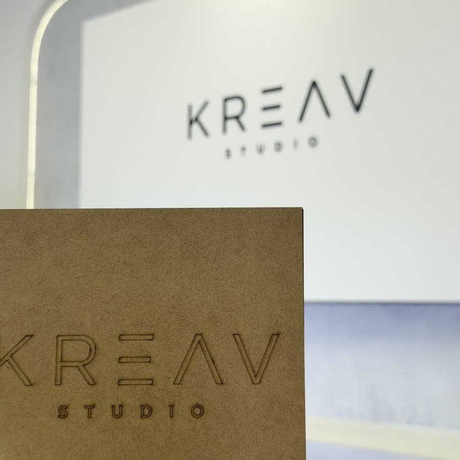 Caixa de MDF com a marca Kreav gravada, na bancada do estúdio