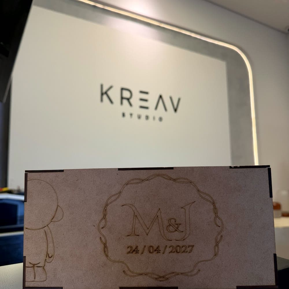 Caixa de MDF com monograma gravado, na bancada do estúdio